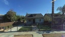 Fresno, CA home bought by Varo as-is: two-story blue-gray house with a fenced yard