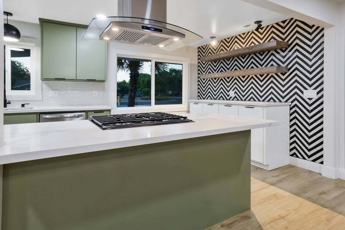 Kitchen: Quartz counters, green cabinets, chevron tile